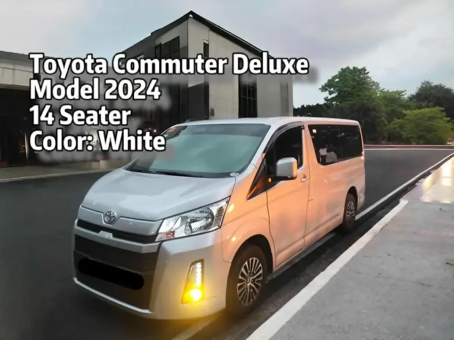 White 2024 Toyota Commuter Deluxe fourteen-seater van on a road at dusk