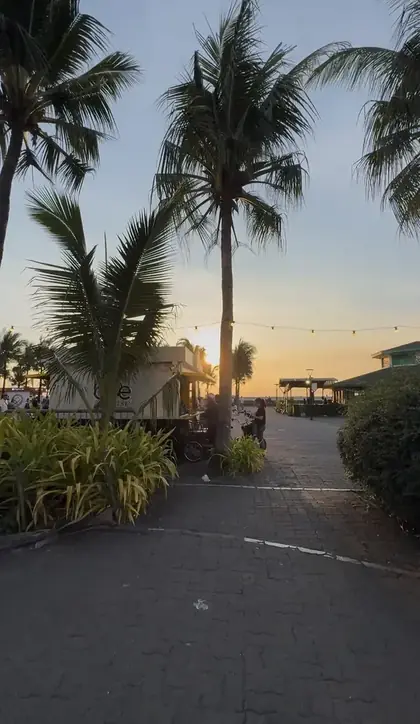 Palm trees and food stalls along Manila Baywalk at sunset
